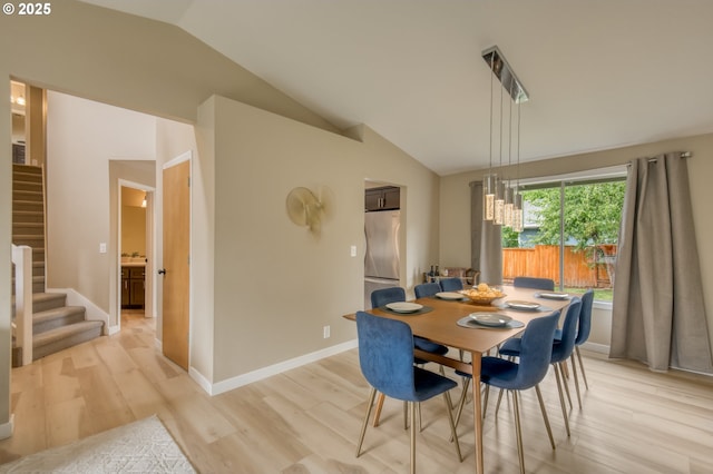 dining area featuring lofted ceiling, stairway, light wood-style flooring, and a chandelier