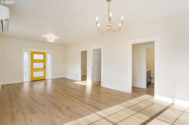 empty room with a notable chandelier and light wood-type flooring