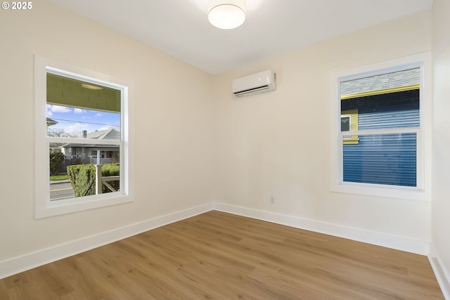 empty room featuring hardwood / wood-style flooring and an AC wall unit