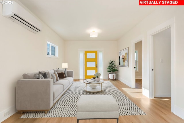 living room with light hardwood / wood-style flooring and an AC wall unit