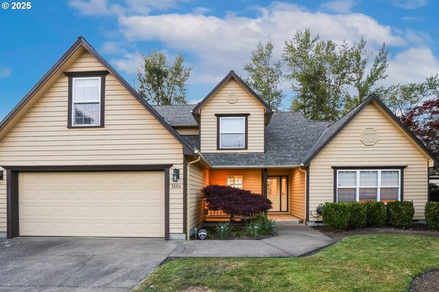 traditional-style house with asphalt driveway, roof with shingles, and a front yard