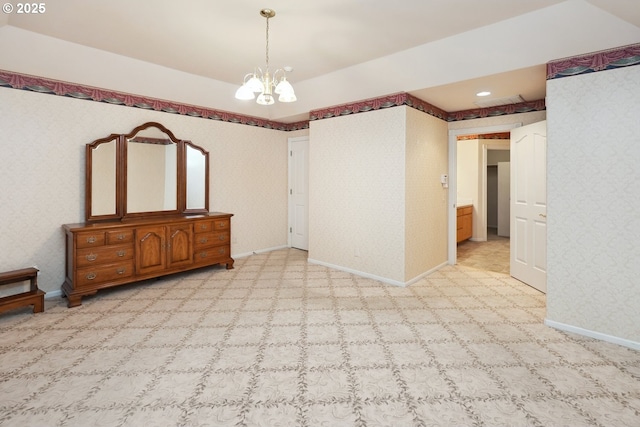 carpeted spare room featuring wallpapered walls, a chandelier, and baseboards