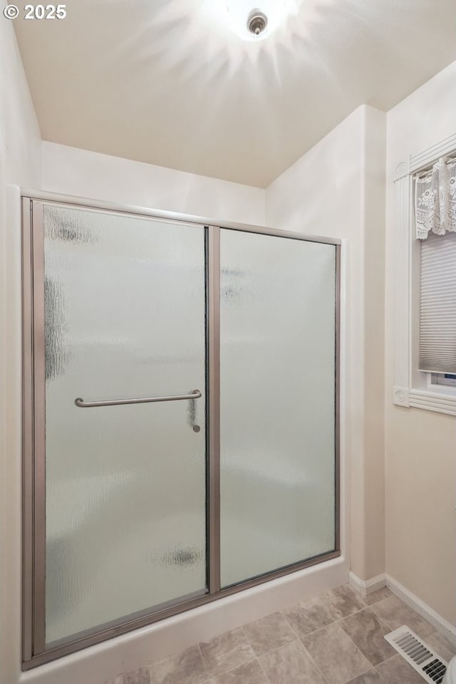full bath with a stall shower and baseboards