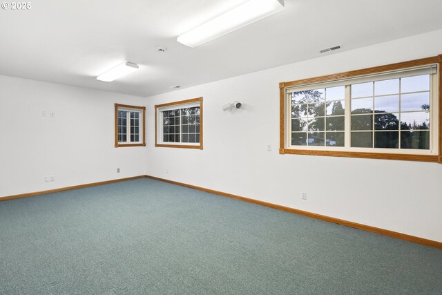 carpeted spare room featuring baseboards