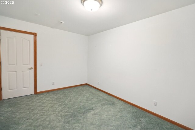 spare room featuring carpet floors and baseboards