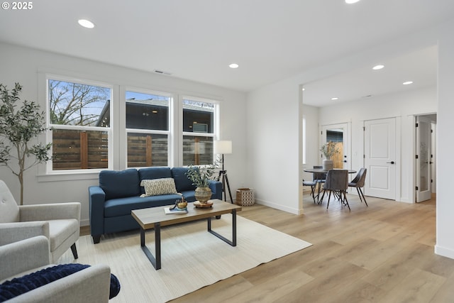 living room with recessed lighting, light wood-style flooring, visible vents, and baseboards