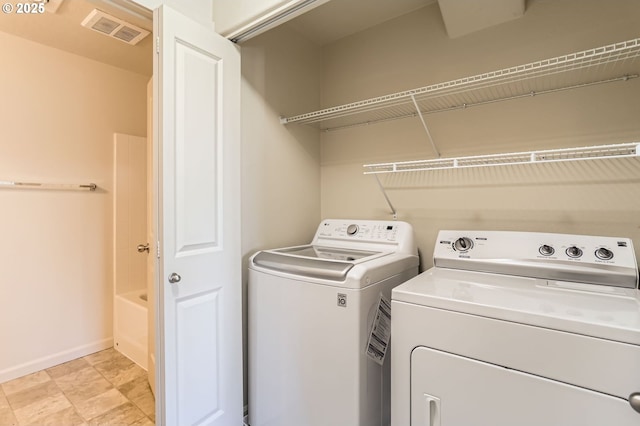laundry room with independent washer and dryer and baseboards