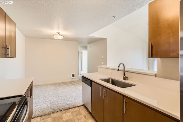 kitchen with a sink, light countertops, stainless steel dishwasher, light colored carpet, and a textured ceiling