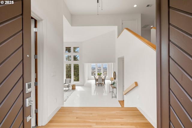 entrance foyer with a towering ceiling and light hardwood / wood-style flooring