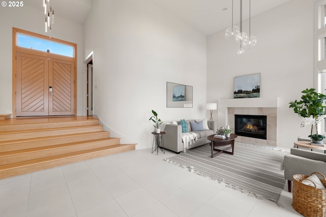 tiled living room with a tile fireplace and a high ceiling