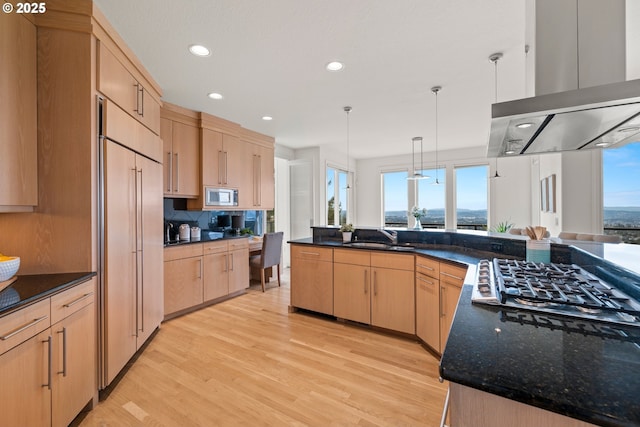 kitchen with sink, hanging light fixtures, built in appliances, island exhaust hood, and light brown cabinetry