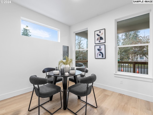 dining room featuring baseboards and light wood-type flooring