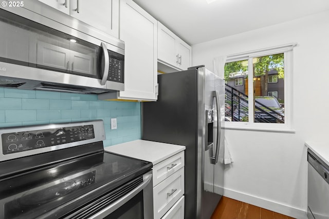 12622 NW Barnes Rd Unit 6, Portland, OR 97229 - kitchen with stainless steel appliances, tasteful backsplash, white cabinets, baseboards, and dark wood-style flooring