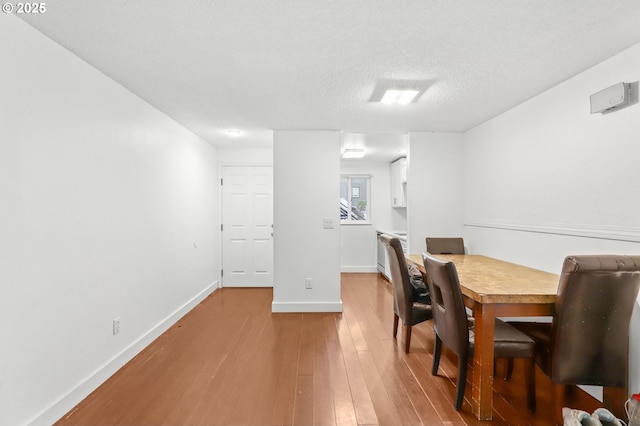 12622 NW Barnes Rd Unit 6, Portland, OR 97229 - dining room featuring hardwood / wood-style flooring, baseboards, and a textured ceiling