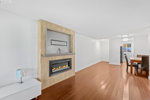 12622 NW Barnes Rd Unit 6, Portland, OR 97229 - unfurnished living room with a fireplace, wood finished floors, and a textured ceiling