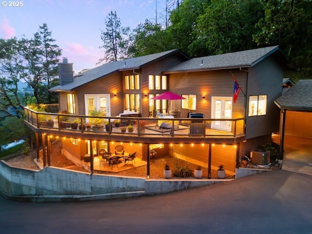 370 Wild Fern Dr, Winchester, OR 97495 - back of house at dusk featuring french doors, a chimney, central AC, and a deck
