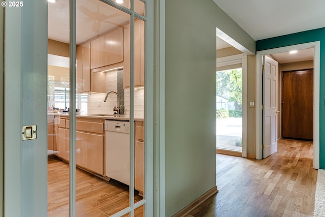 hallway featuring a sink and light wood-style floors