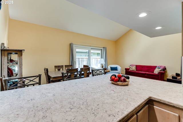 kitchen featuring recessed lighting, open floor plan, light stone countertops, and lofted ceiling