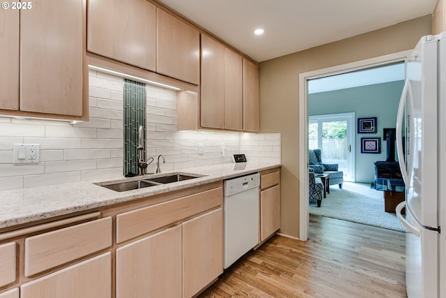 kitchen with light wood finished floors, light brown cabinets, and white appliances