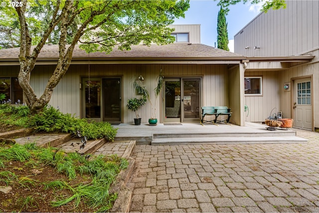 back of house featuring a shingled roof and a deck