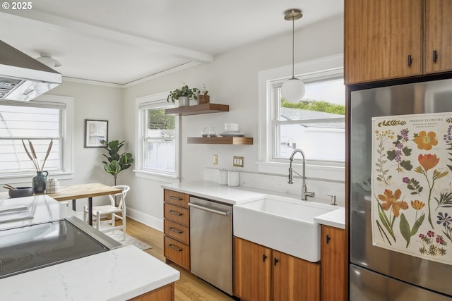 3737 NE 74th Ave, Portland, OR 97213 - kitchen with stainless steel appliances, a sink, light wood-style floors, brown cabinetry, and crown molding