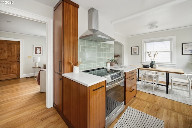 3737 NE 74th Ave, Portland, OR 97213 - kitchen with range hood, electric stove, brown cabinetry, tasteful backsplash, and light wood-style floors