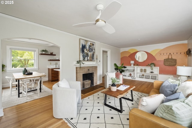 3737 NE 74th Ave, Portland, OR 97213 - living room featuring light wood-type flooring, a fireplace, ceiling fan, arched walkways, and ornamental molding