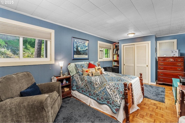 bedroom with a closet, parquet floors, and ornamental molding