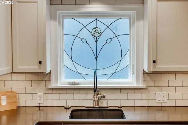 kitchen view of white cabinets and tasteful backsplash
