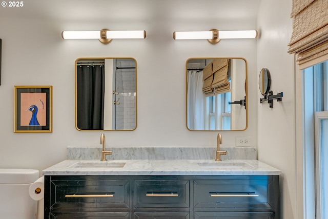 bathroom with toilet and double vanity
