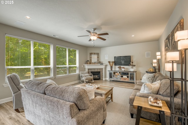 10380 SW Madrid Loop, Wilsonville, OR 97070 - living room with light wood-style flooring, ceiling fan, a tiled fireplace, and recessed lighting