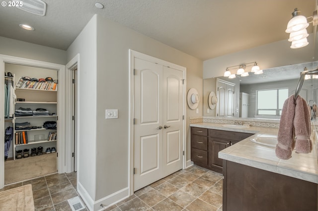 10380 SW Madrid Loop, Wilsonville, OR 97070 - full bath with vanity, a walk in closet, and a textured ceiling