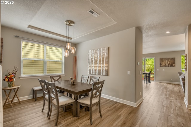 10380 SW Madrid Loop, Wilsonville, OR 97070 - dining room featuring a textured ceiling, light wood-style floors, a raised ceiling, and recessed lighting