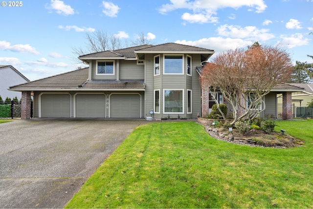 view of front of home featuring an attached garage, aphalt driveway, and a front yard