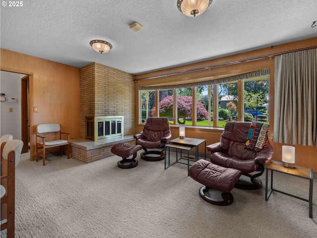 carpeted living room featuring a brick fireplace, a textured ceiling, and wood walls