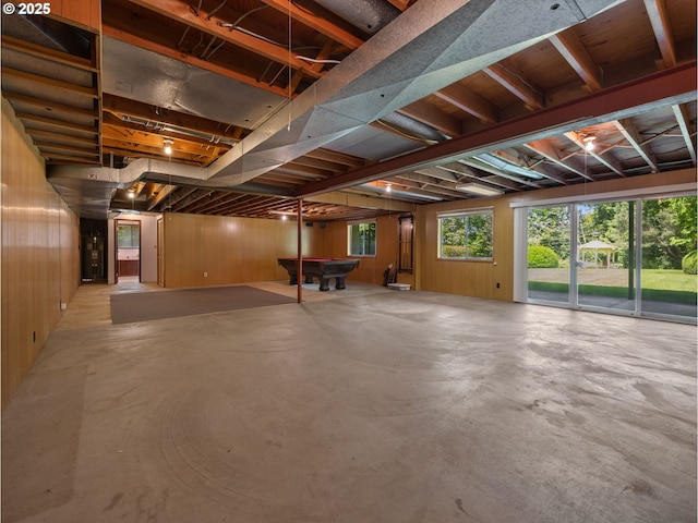 basement featuring pool table, wood walls, and water heater