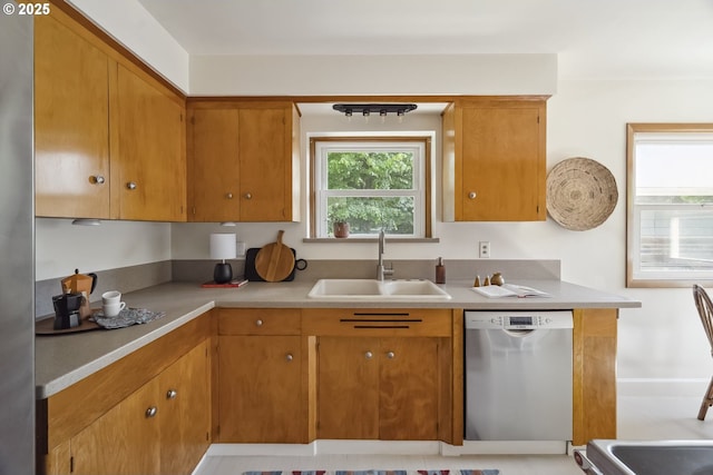 7625 N Fowler Ave, Portland, OR 97217 - kitchen with stainless steel dishwasher, a sink, light countertops, and brown cabinets