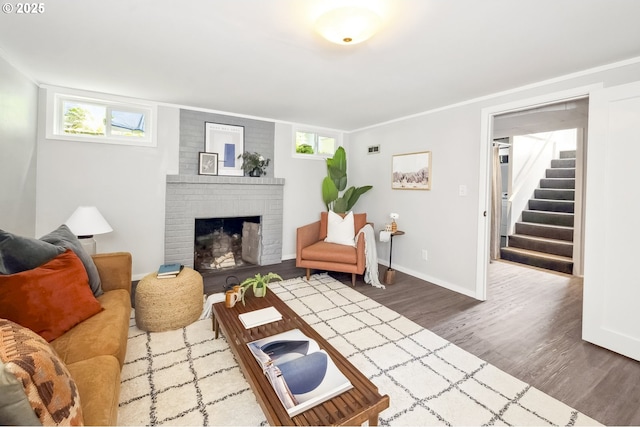 7625 N Fowler Ave, Portland, OR 97217 - living room with wood finished floors, stairs, a brick fireplace, and baseboards