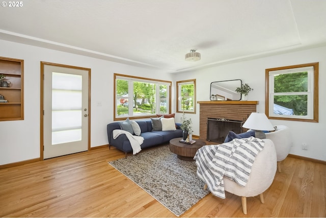 7625 N Fowler Ave, Portland, OR 97217 - living room featuring a fireplace, light wood-style floors, and baseboards
