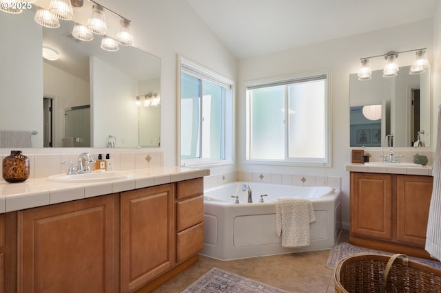 bathroom with vaulted ceiling, tile patterned flooring, a bath, two vanities, and a shower with door