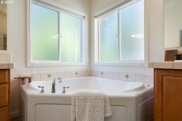full bath with healthy amount of natural light, vanity, and a garden tub