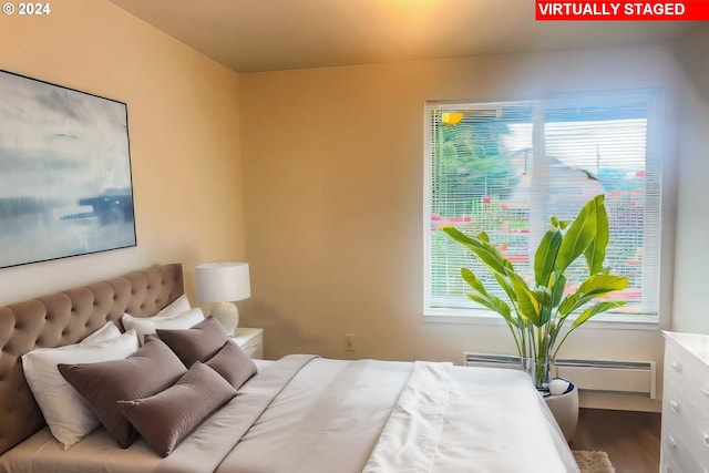 bedroom with hardwood / wood-style flooring and a baseboard radiator