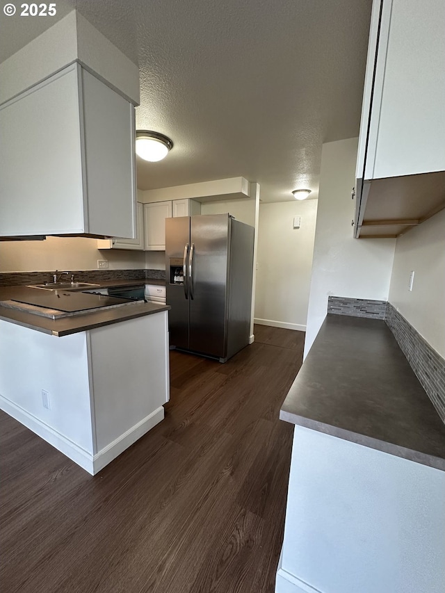 kitchen with sink, a textured ceiling, white cabinets, dark hardwood / wood-style flooring, and stainless steel fridge with ice dispenser