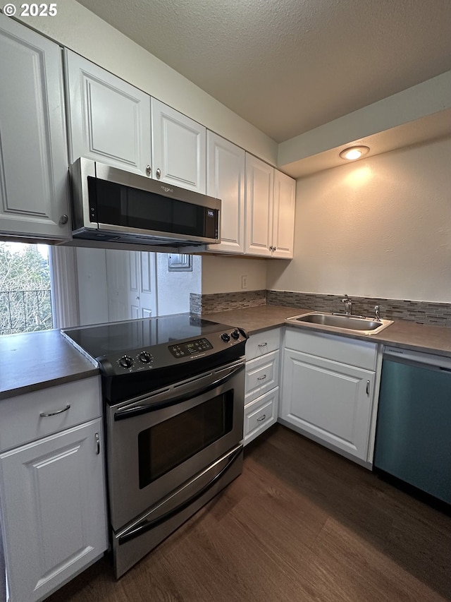 kitchen with white cabinetry, sink, dark hardwood / wood-style floors, and appliances with stainless steel finishes