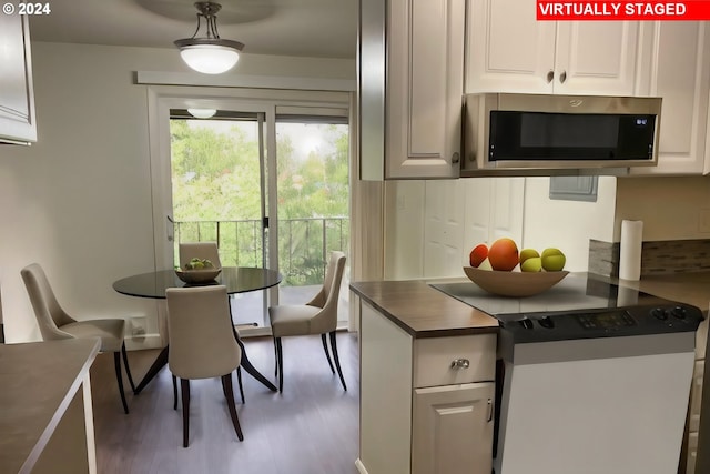 kitchen with dark hardwood / wood-style flooring, hanging light fixtures, and white cabinets