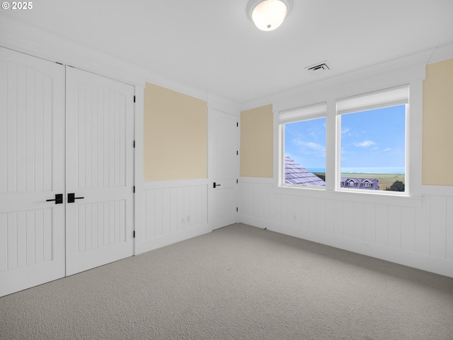 88902 Pinehurst Rd, Gearhart, OR 97138 - unfurnished bedroom featuring wainscoting, carpet flooring, and a closet