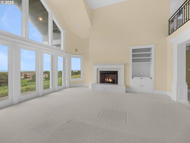88902 Pinehurst Rd, Gearhart, OR 97138 - unfurnished living room with a towering ceiling, a high end fireplace, carpet floors, baseboards, and built in features