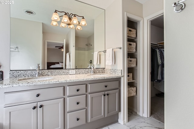 full bath with marble finish floor, a sink, visible vents, and walk in shower