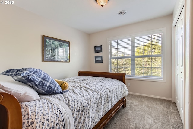 bedroom featuring visible vents, baseboards, a closet, and carpet