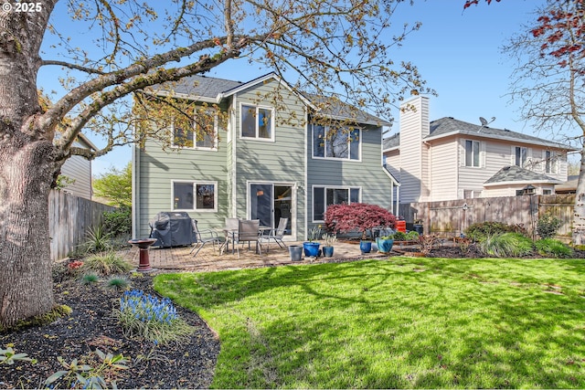 rear view of property with a patio, a yard, and a fenced backyard